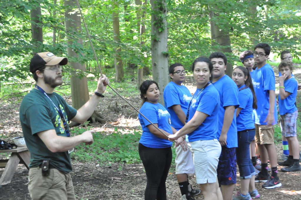 Gretna Glen’s Dan Kirby teaches the “Flying Squirrel” ropes course team activity to Latino Camp participants. John Coleman photos