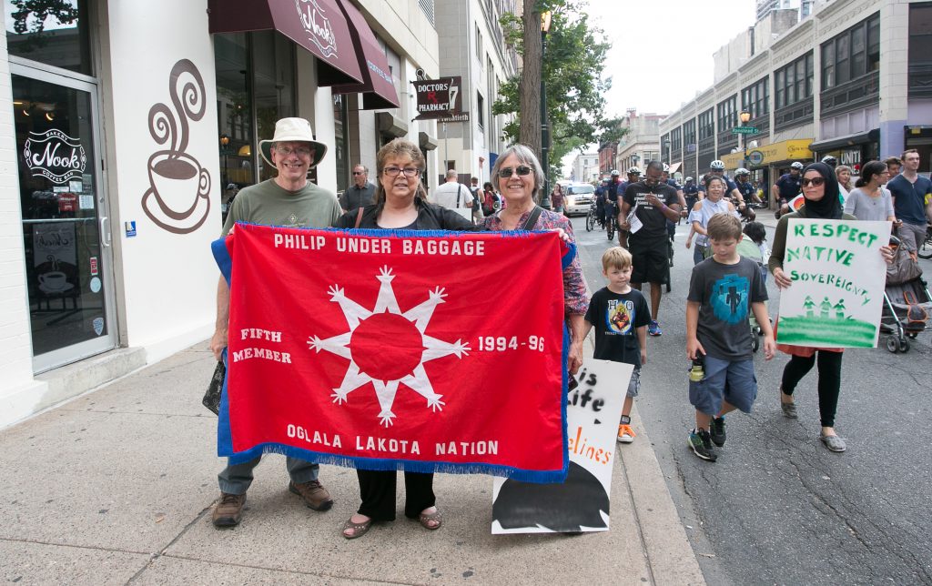 (From right) Verna Colliver and Sandi Cianciulli hold a banner with another marcher. Armen Elliott photo